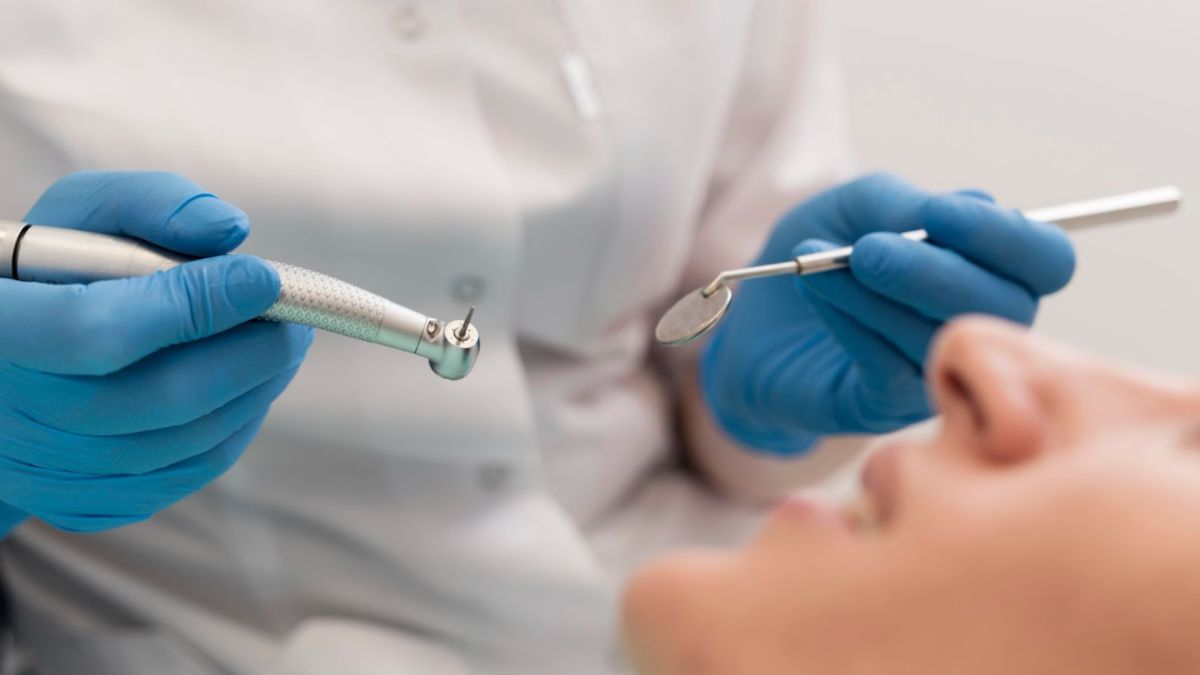 A dentist performs teeth cleaning with a dental tool, serving patients in Haverhill, FL.