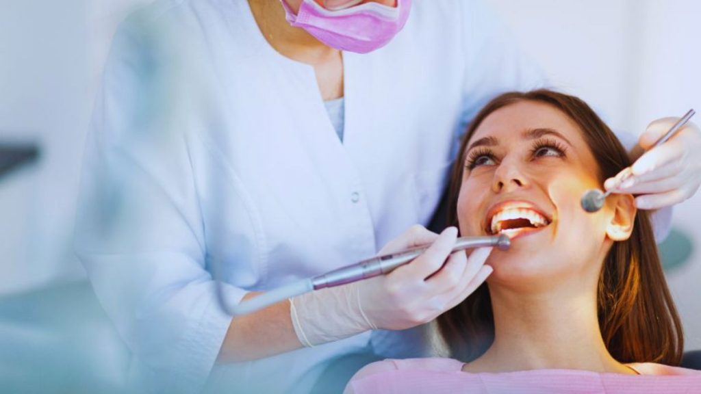 A dentist checking a woman's teeth during a routine dental appointment, emphasizing patient care and dental hygiene.