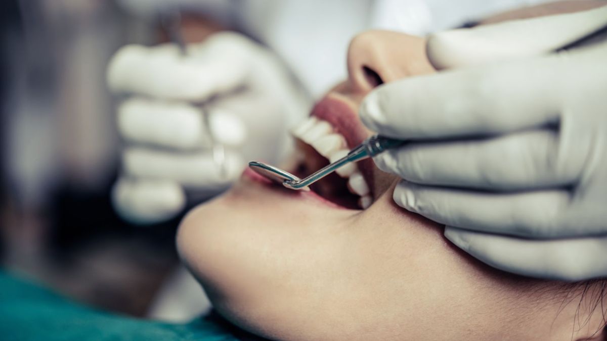 A dentist cleaning a woman's teeth, highlighting dental services available in Lake Worth, FL.